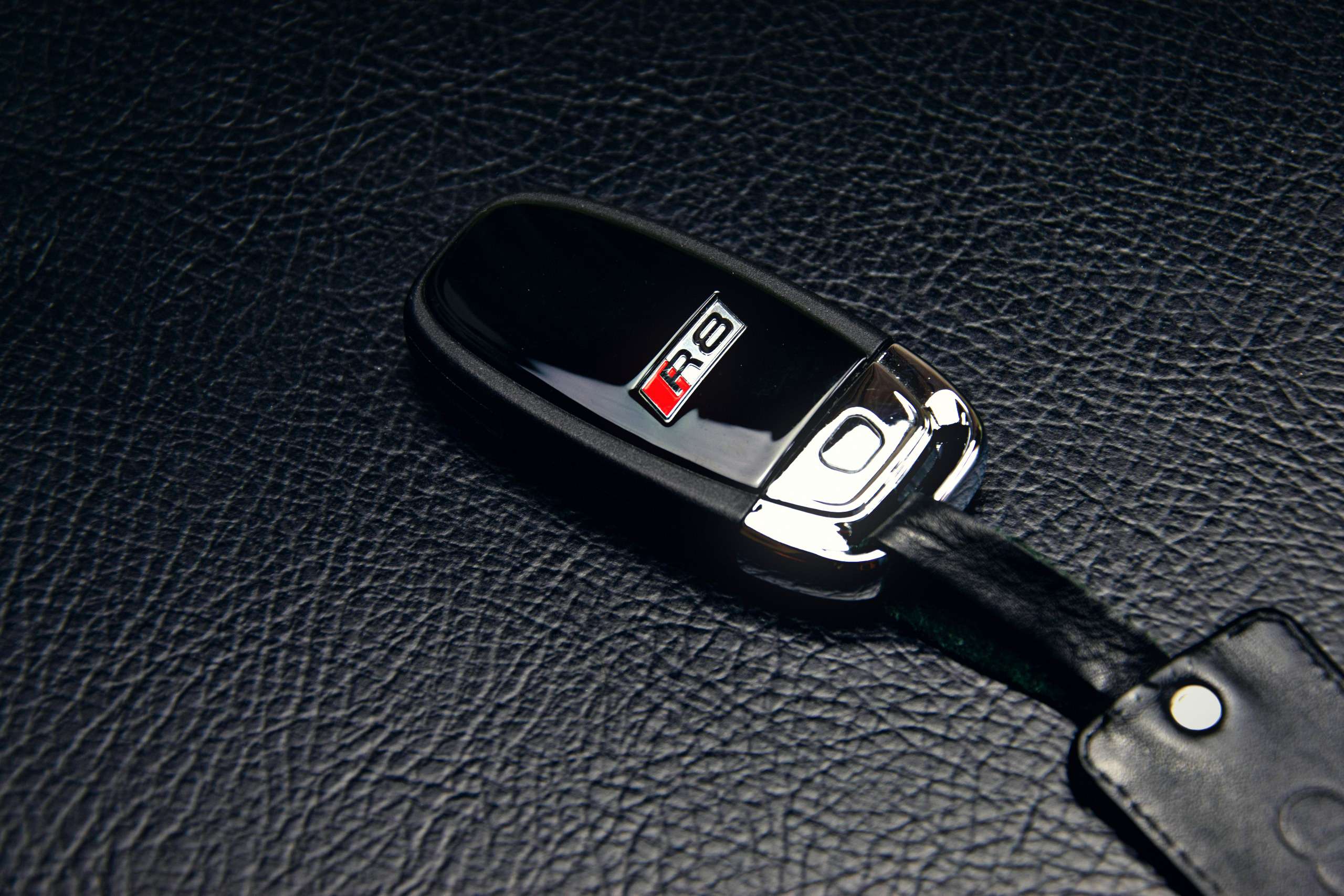 Smart car key fob resting on a leather surface
