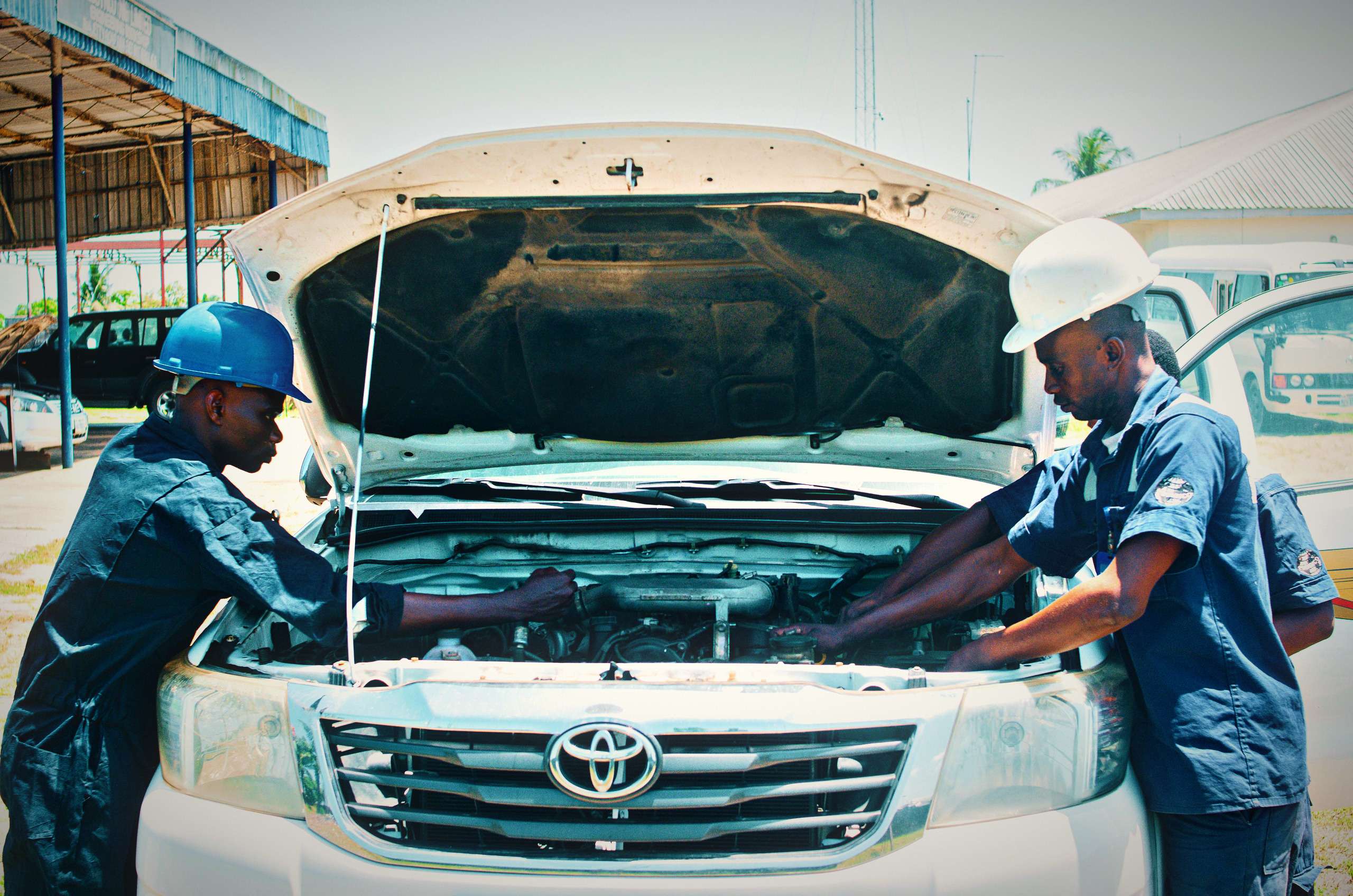 Mechanics working together on a car engine