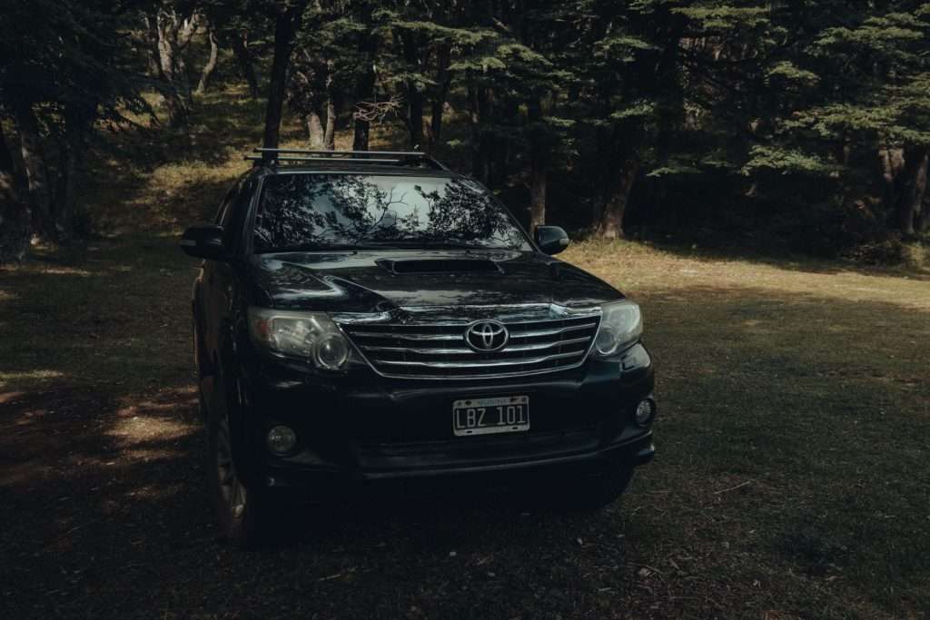 Toyota SUV parked in moody forest light