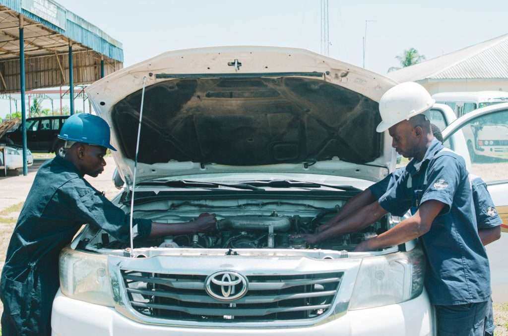 Mechanics working together on a car engine