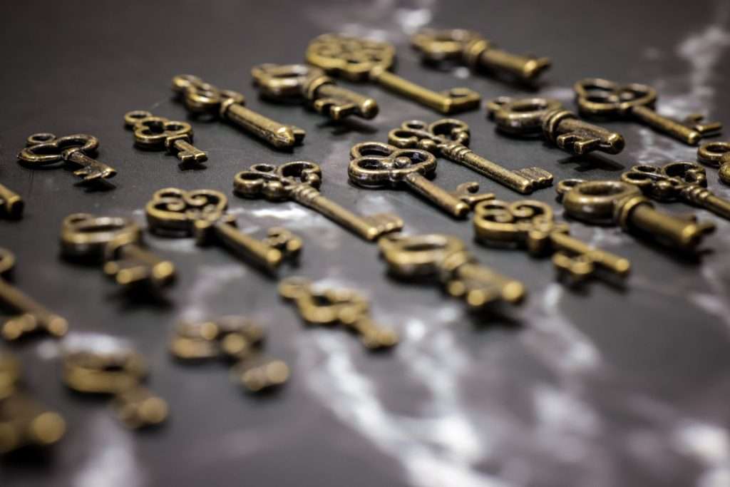 Collection of brass keys scattered on a dark surface